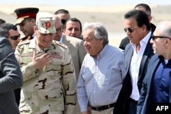 U.N. Secretary-General Antonio Guterres, center, is flanked by the Egyptian Second Army in Sinai Chief Mohammad Abdel Rahman, left, and Egyptian Health Minister Khaled Abdel Ghaffar, right, upon landing at Egypt's al-Arish Airport near the Rafah border on March 23, 2024.