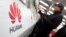 A man looks at a Huawei mobile phone as he shops at an electronic market in Shanghai, Jan. 22, 2013.