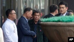 Philippine President Rodrigo Duterte, center walks out from a shopping mall in Beijing, China, Wednesday, Oct. 19, 2016. 