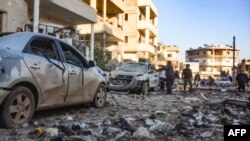 People check damage in a street following an airstrike by Syrian government forces in the town Maarrat Misrin, in Syria’s northwestern Idlib province, Feb. 25, 2020. 