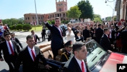 El nuevo presidente de Paraguay, Santiago Peña, y su esposa, Leticia Ocampos, saludan desde un automóvil mientras se dirigen a la Catedral el día de la asunción de Peña en Asunción, Paraguay, el martes 15 de agosto de 2023. 