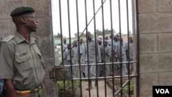 A corrections officer looks on as inmates gather near housing units at Naivasha Maximum Prison in Kenya, October 2014. (Gabe Joselow / VOA) 