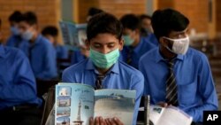 Students wearing face masks to prevent the spread of coronavirus, attend their class at a school, in Peshawar, Pakistan, Sept. 15, 2020.