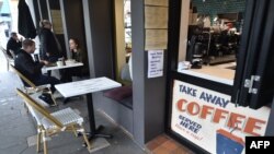 FILE - Customers eat in a cafe in Sydney, Australia, after more than seven weeks of COVID-19 restrictions on May 15, 2020.