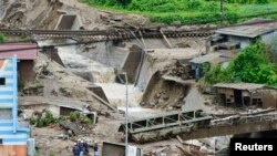 Damaged cars and buildings are seen after a landslide caused by heavy rains due to Typhoon Neoguri in Nagiso town, Nagano prefecture, in this photo taken by Kyodo, July 10, 2014.