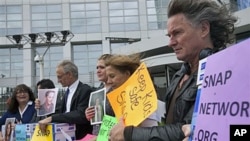 Members of Survivors Network of those Abused by Priests (SNAP) pose in front of the International Criminal Court (ICC) in The Hague, Netherlands, Tuesday, September 13, 2011.