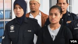 Wilfrida Soik (kanan) dikawal oleh polisi Malaysia saat memasuki ruang sidang Mahkamah Tinggi di Kota Bharu, negara bagian Kelantan hari Senin 30/9 (foto: VOA/Munarsih).