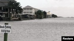 FILE - Homes sit on the edge of the Gulf of Mexico in Plaquemines Parish, Louisiana, Oct. 7, 2017. Forecasters say two storms are likely to move into the Gulf of Mexico and become hurricanes by early next week. 