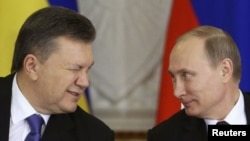 Presiden Ukraina saat itu Viktor Yanukovych (kiri) mengedipkan mata kepada Presiden Rusia Vladimir Putin saat upacara penandatanganan setelah pertemuan Komisi Antarnegara Rusia-Ukraina di Kremlin di Moskow, 17 Desember 2013. (Foto: REUTERS/Sergei Karpukhin)