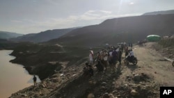 Miners, rescuers andothers look at the jade mine site where a landslide accident took place in Hpakant township, Kachin state, Myanmar, Aug. 13, 2023. The landslide left scores of people missing, and a search and rescue operation was underway, a rescue official said.