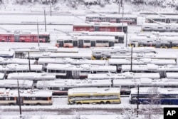 An aerial view of parked trolley buses during heavy snowfall in Sarajevo, Bosnia, Dec. 24, 2024.