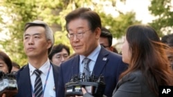 한국의 제1야당인 더불어민주당의 이재명 대표(가운데)가 2024년 11월 15일 서울중앙지방법원을 나서고 있다.