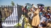 Friends and relatives of the Ziwangwe family, during the unveiling of the tombstone of late Kindness Ziwangwe at a cemetary in Harare, Zimbabwe, Saturday, Dec 7, 2024. (AP Photo/Aaron Ufumeli)