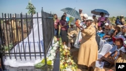 Friends and relatives of the Ziwangwe family, during the unveiling of the tombstone of late Kindness Ziwangwe at a cemetary in Harare, Zimbabwe, Saturday, Dec 7, 2024. (AP Photo/Aaron Ufumeli)