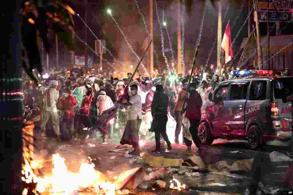 Fire crackers explode near supporters of presidential candidate Prabowo Subianto during clashes with the police in Jakarta, Indonesia. President Joko Widodo said authorities have the situation under control after six people died in the riots.