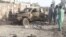 Residents look at an Army vehicle which was damaged during battle between Afghan security forces and Taliban in Farah province, Afghanistan, May 16, 2018.