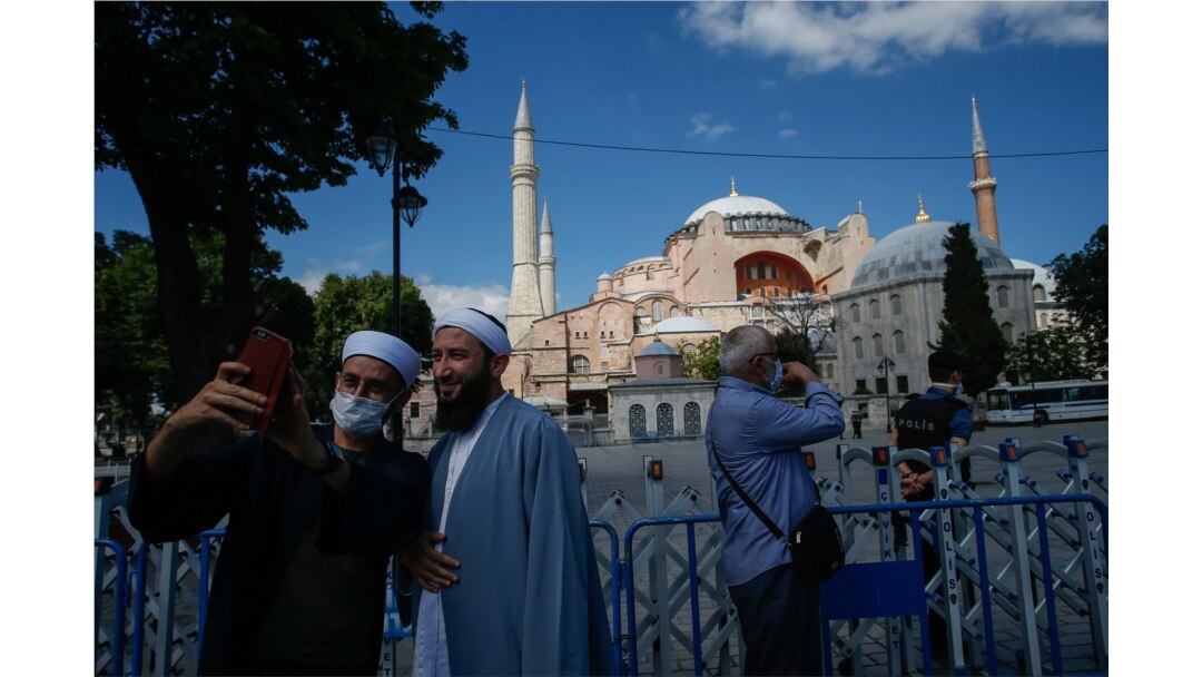 Para turis berfoto di depan Hagia Sophia di Istanbul, Turki (11/7).