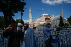 Para turis berfoto di depan Hagia Sophia di Istanbul, Turki (11/7).
