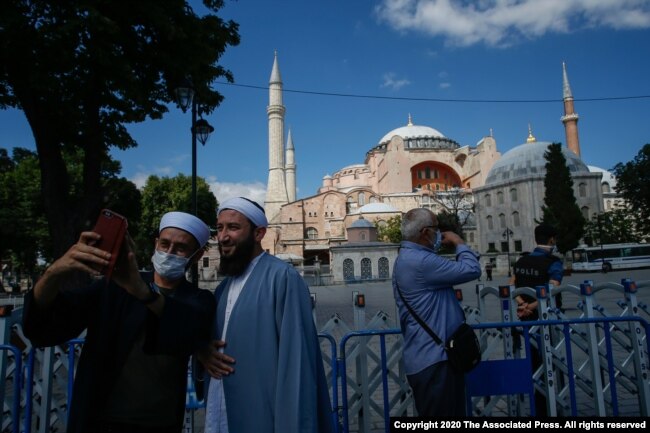Para turis berfoto di depan Hagia Sophia di Istanbul, Turki (11/7).