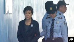 FILE - In this Oct. 10, 2017 file photo, Former South Korean President Park Geun-hye, left, arrives to attend a hearing on the extension of her detention at the Seoul Central District Court in Seoul, South Korea.