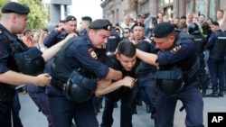 Policías detienen a un hombre durante un mitin no autorizado en el centro de Moscú, el sábado 27 de julio de 2019. Los manifestantes exigían que se permitiera a los candidatos de la oposición postularse para el concejo municipal de Moscú.