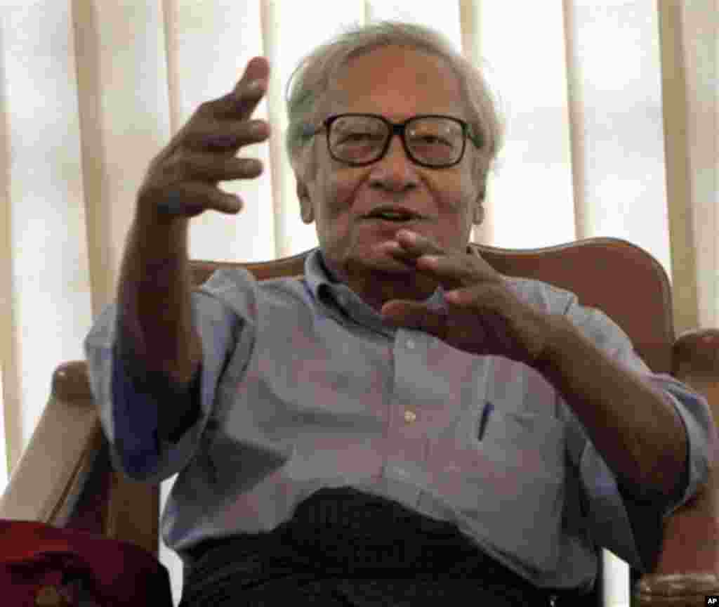 Win Tin, a senior leader of the detained pro-democracy leader Aung San Suu Kyi's National League for Democracy Party, talks to the family of Khun Tun Oo, a senior leader of the party, who is still serving the 93-year jail sentence, to comfort them at the 