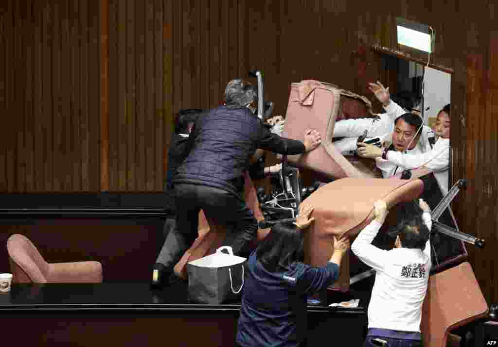 Lawmakers from the main opposition Kuomintang, in white, try to break into Parliament where the Democratic Progressive Party occupied the night to avoid the passing of controversial bills at the Legislative Yuan in Taipei.