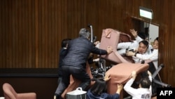 Lawmakers from the main opposition Kuomintang, in white, try to break into Parliament where the Democratic Progressive Party occupied the night to avoid the passing of controversial bills at the Legislative Yuan in Taipei.