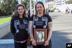 Gina, right, and Tanya Sammons hold a photo of their late sister Alva as they arrive at Parliament House in Wellington, New Zealand, ahead of the apology to the survivors of abuse in state, faith-based and foster care, Nov. 12, 2024.