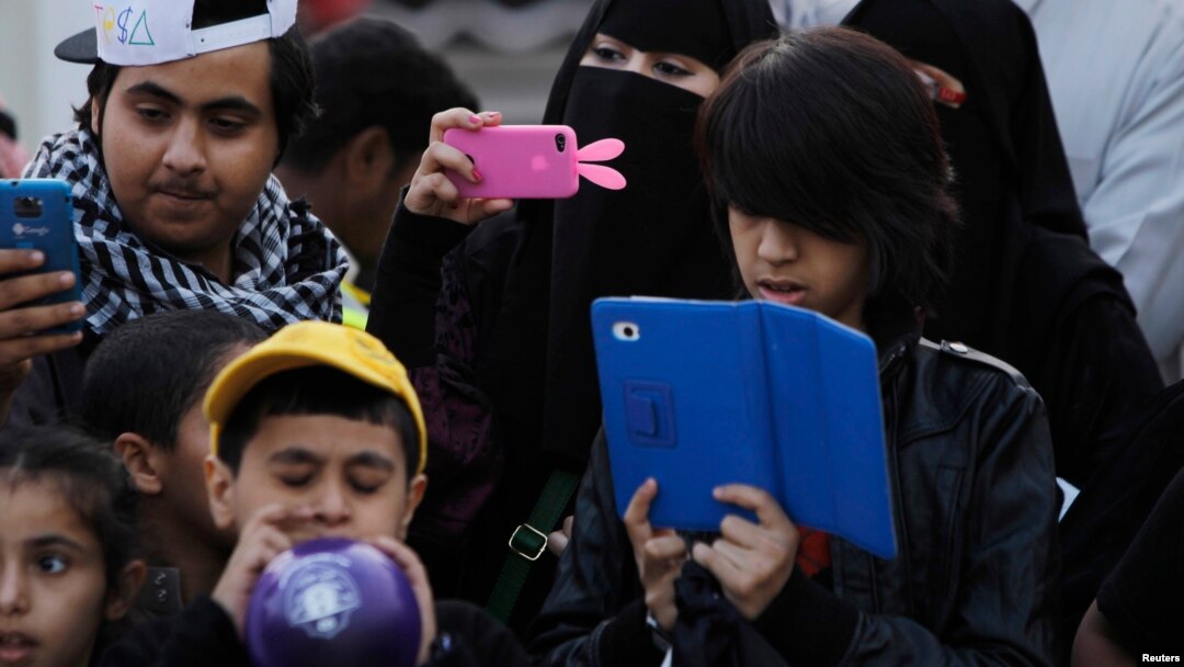 FILE - A family takes pictures with their mobile phones and tablet computer at the 27th Janadriya festival on the outskirts of Riyadh, Saudi Arabia, Feb. 13, 2012. 
