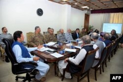 In this handout picture released by Prime Minister Office (PMO) August 7, 2019, Pakistan's Prime Minister Imran Khan (L) chairs a National Security Committee meeting in Islamabad.