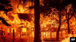 یک خانه مسکونی در حال سوختن در شعله‌های آتش‌سوزی جنگلی «دیکسی» - شهرستان پلوماس، کالیفرنیا - ۲۴ ژوئیه ۲۰۲۱