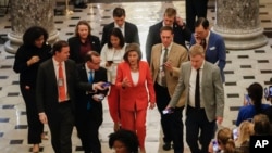 House Speaker Nancy Pelosi of California, center, is followed by members of the media as she leaves the House Chamber on Capitol Hill in Washington, Oct. 31, 2019. 