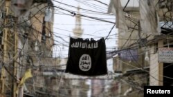 FILE - An Islamic State flag hangs amid electric wires over a street in southern Lebanon, Jan. 19, 2016.