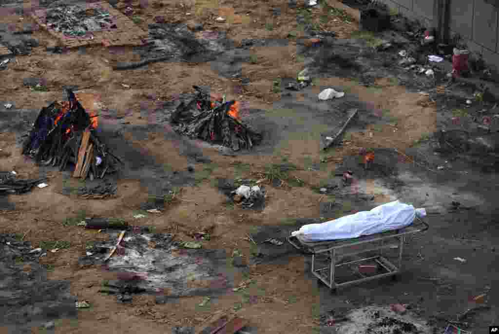 Multiple funeral pyres of people who died of COVID-19 are seen burning in an area that has been converted into a crematorium for the mass cremation of coronavirus victims, in New Delhi, India, April 21, 2021.