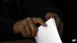 An Egyptian voter casts her vote in a polling station in Cairo, Egypt, March 19, 2011