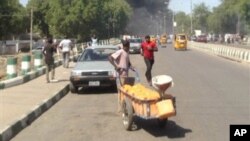 Mutane suna gudu yayin da hayaki ke shiga cikin samaniya bayan da bom ya fashe a inda sojoji ke girke a garin Maiduguri. (File Photo)