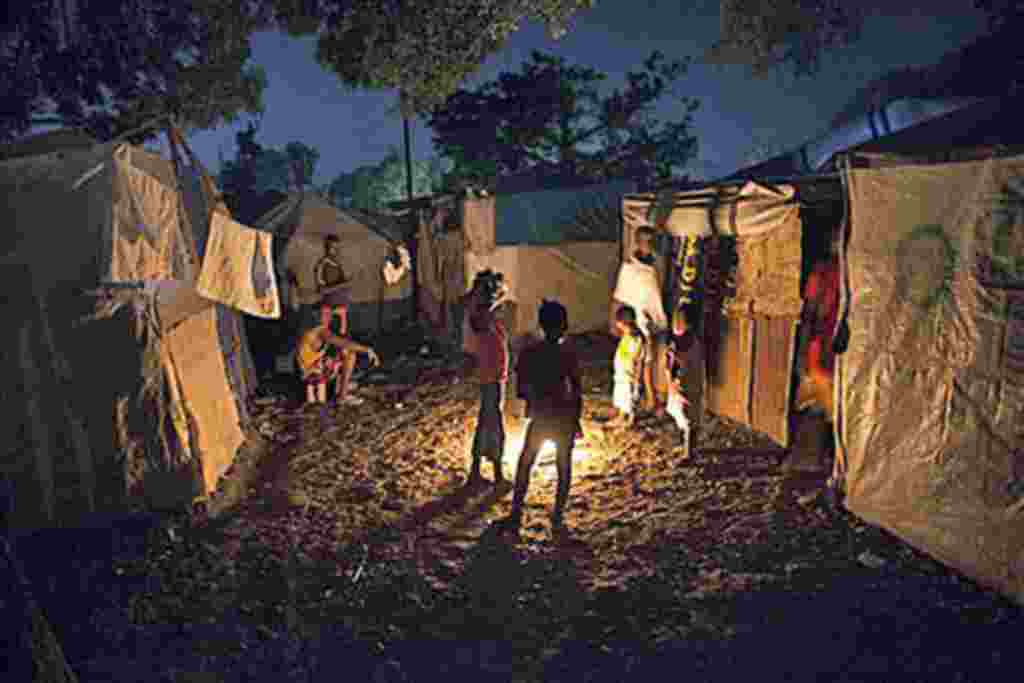 Earthquake survivors gather around a bonfire at a makeshift camp in Port-au-Prince, Haiti, where Tropical Storm Tomas might be headed, 01 Nov 2010