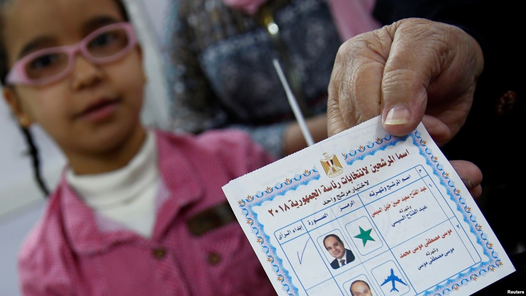 Seorang perempuan Mesir memperlihatkan surat suaranya dengan menandai pilihan untuk Presiden Mesir Abdel Fattah el-Sissi, sebelum memasukkan kertas suara dalam pemilihan presiden hari pertama di Kairo, Mesir, 26 Maret 2018.