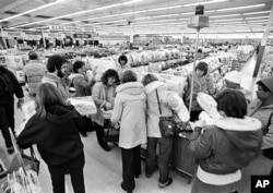 FILE - Kmart shoppers mill around the flashing blue light, sign of the "Blue Light Special," at the first Kmart ever built, in Garden City, Michigan, on March 1, 1982.