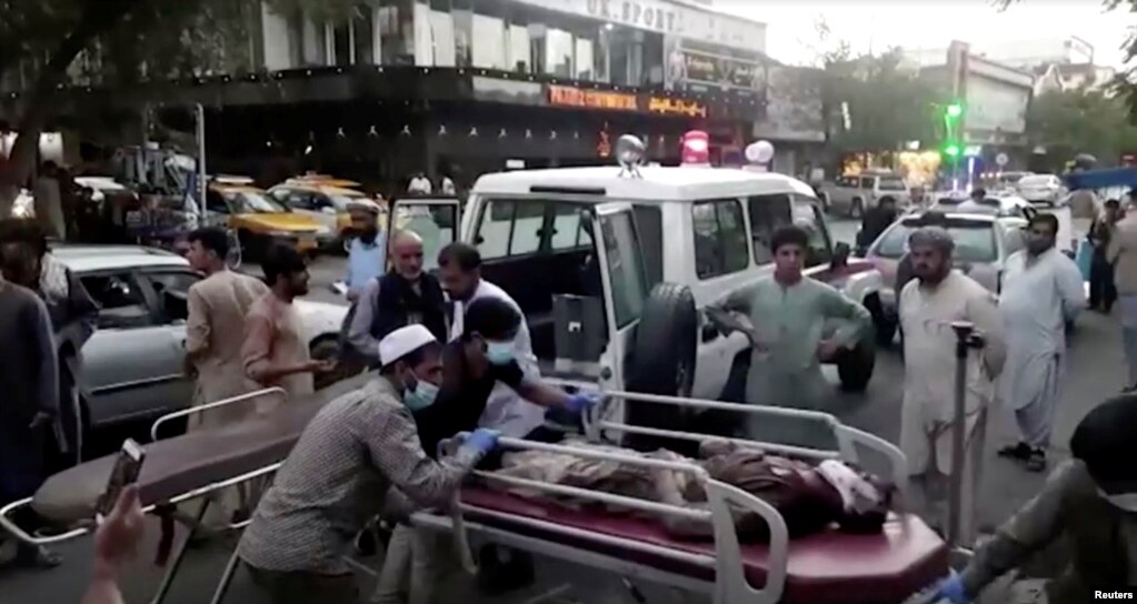 视频截图显示，在阿富汗喀布尔机场外发生袭击事件后，人们将一名受伤人员送往医院。(2021 8月26 日)(photo:VOA)