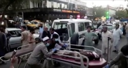A screen grab shows people carrying an injured person to a hospital after an attack at Kabul's airport, in Kabul, Afghanistan Aug. 26, 2021. An Islamic State offshoot claimed responsibility for deadly suicide attacks outside the airport.
