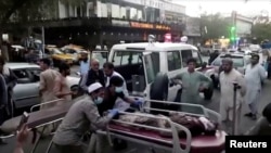 A screen grab shows people carrying an injured person to a hospital after an attack at Kabul's airport, in Kabul, Afghanistan Aug. 26, 2021. An Islamic State offshoot claimed responsibility for deadly suicide attacks outside the airport.