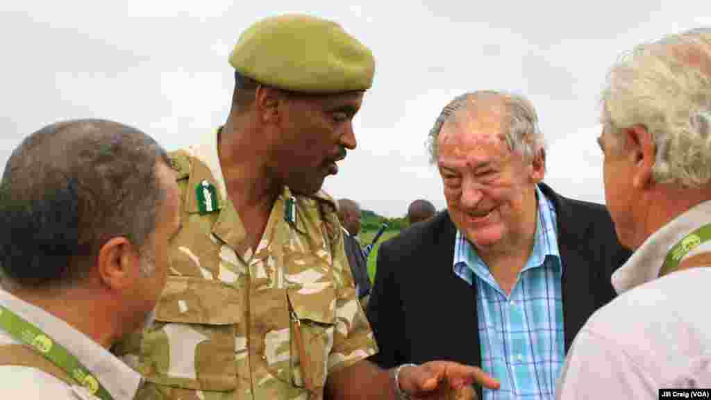 Kenya Wildlife Service Director General Kitili Mbathi, center left, and Kenya Wildlife Service chairman Richard Leakey, center right, speak with attendees at Kenya’s ivory burn, Nairobi National Park, Kenya, April 30, 2016.