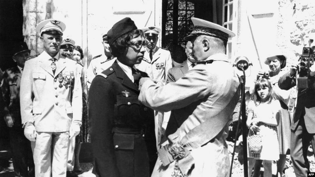 FILE - US-born singer-entertainer Joséphine Baker (C left) receives the Legion of Honor and the Croix de Guerre with palm in her Milandes Castle, Aug. 19, 1961.