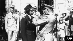 FILE - US-born singer-entertainer Joséphine Baker (C left) receives the Legion of Honor and the Croix de Guerre with palm in her Milandes Castle, Aug. 19, 1961.