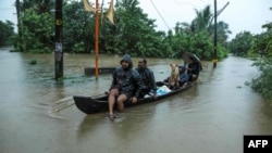TOPSHOT - Residents are being evacuated from their home to a safer place following floods warnings, on a wooden boat in Kochi in the Indian state of Kerala on August 10, 2019. Floods have killed at least 100 people and displaced hundreds of…