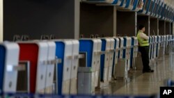 A guard leans on a check-in counter at the airport where hundreds of flights have been canceled due to a nationwide strike, in Buenos Aires, Argentina, Sept. 25, 2018. 