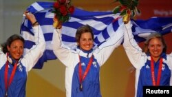 FILE - From L to R: Sofia Bekatorou, Sofia Papadopoulou and Virginia Kravarioti of Greece celebrate with their bronze medals after the medal race in the Yingling class competition during the Beijing 2008 Olympic Games in Qingdao, Aug. 17, 2008. 