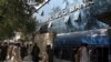 Afghans wait for hours to try to withdraw money, in front a bank, in Kabul, Aug. 15, 2021.